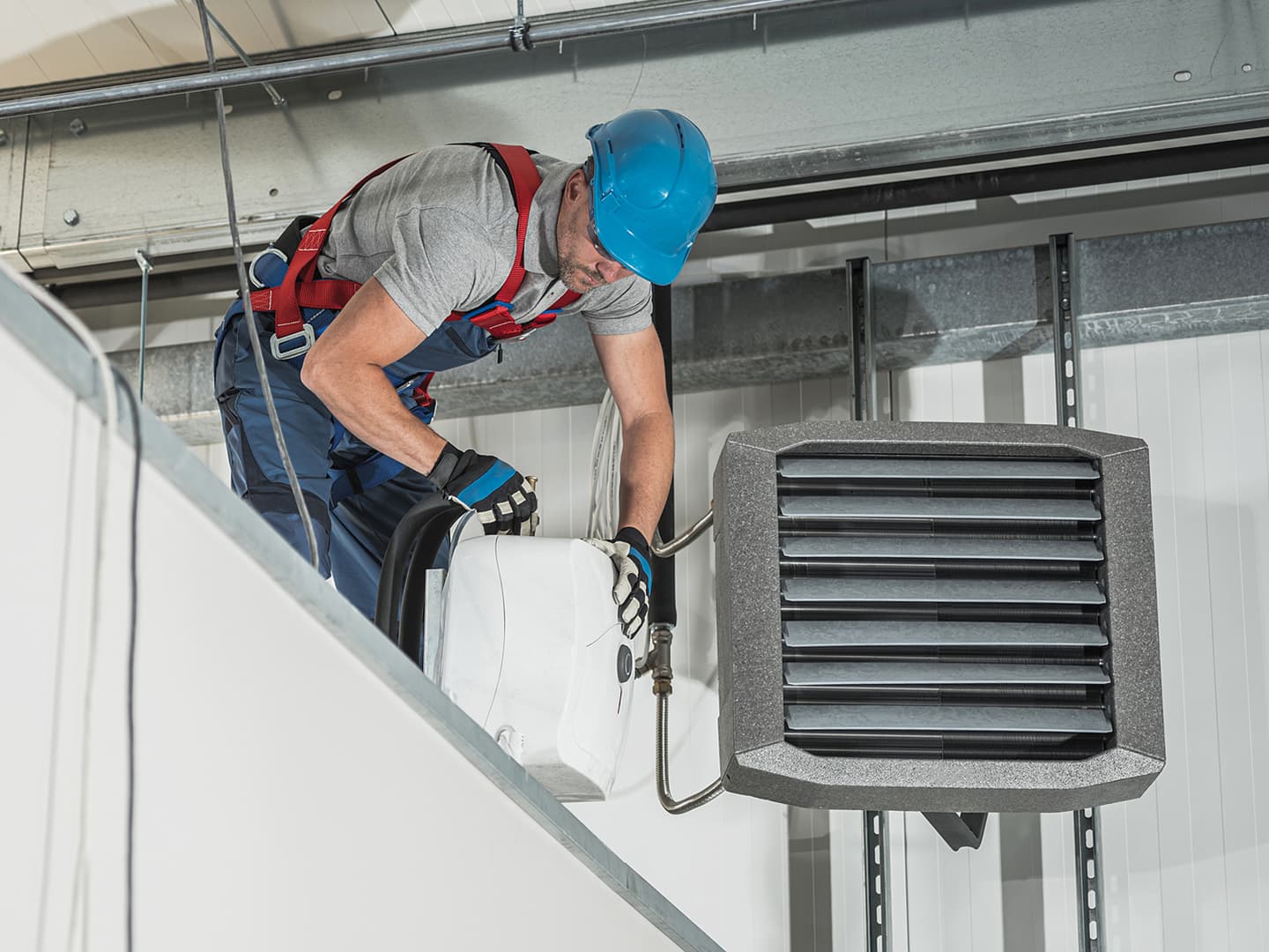 A commercial HVAC technician working on an AC unit