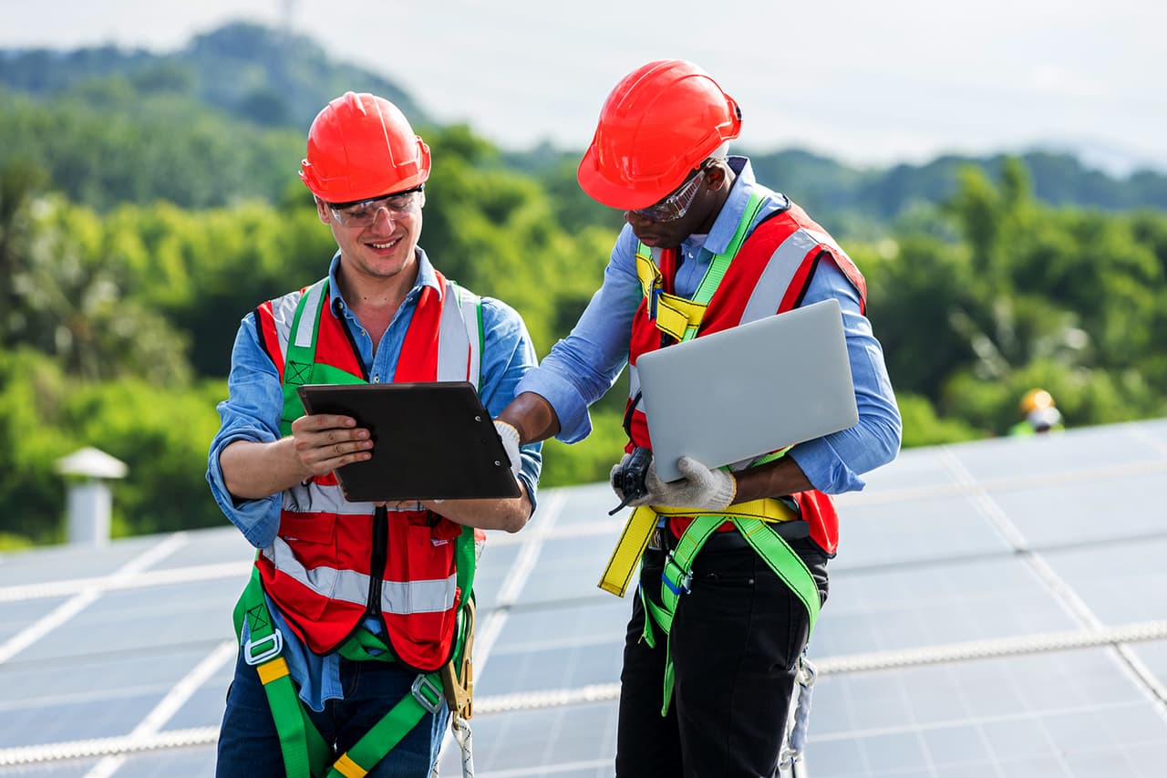 Two solar engineers on a commercial rooftop