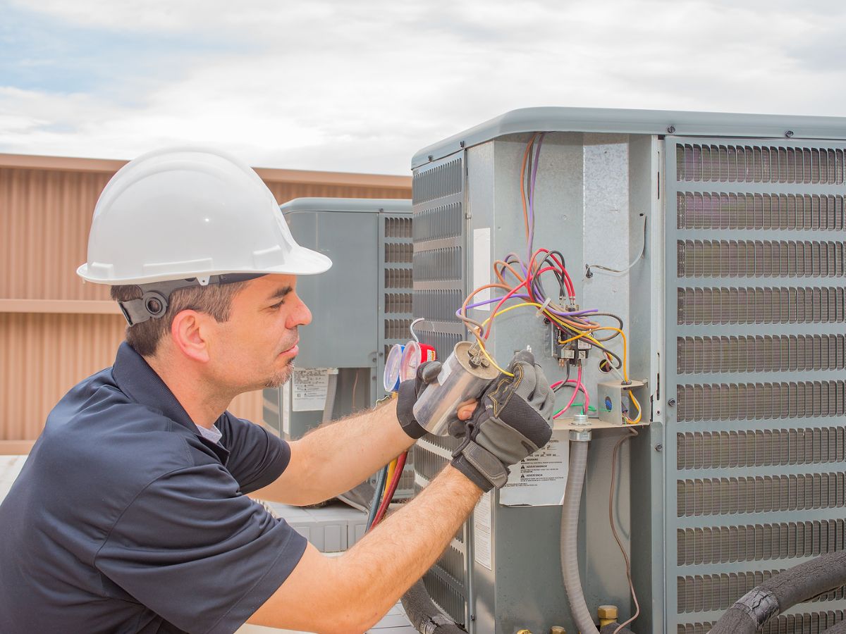 Worker examining an electrical component for HVAC.