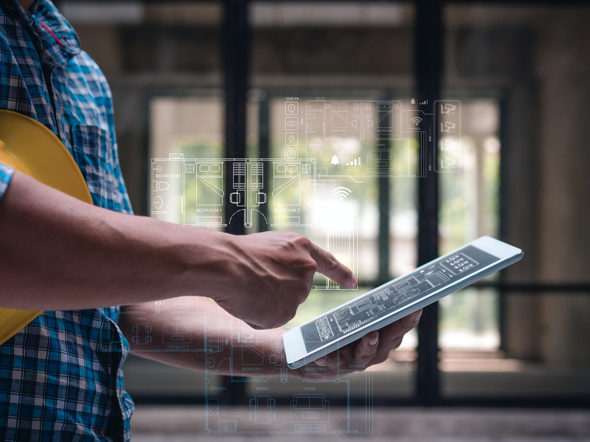 Man using tablet to view blueprint design.