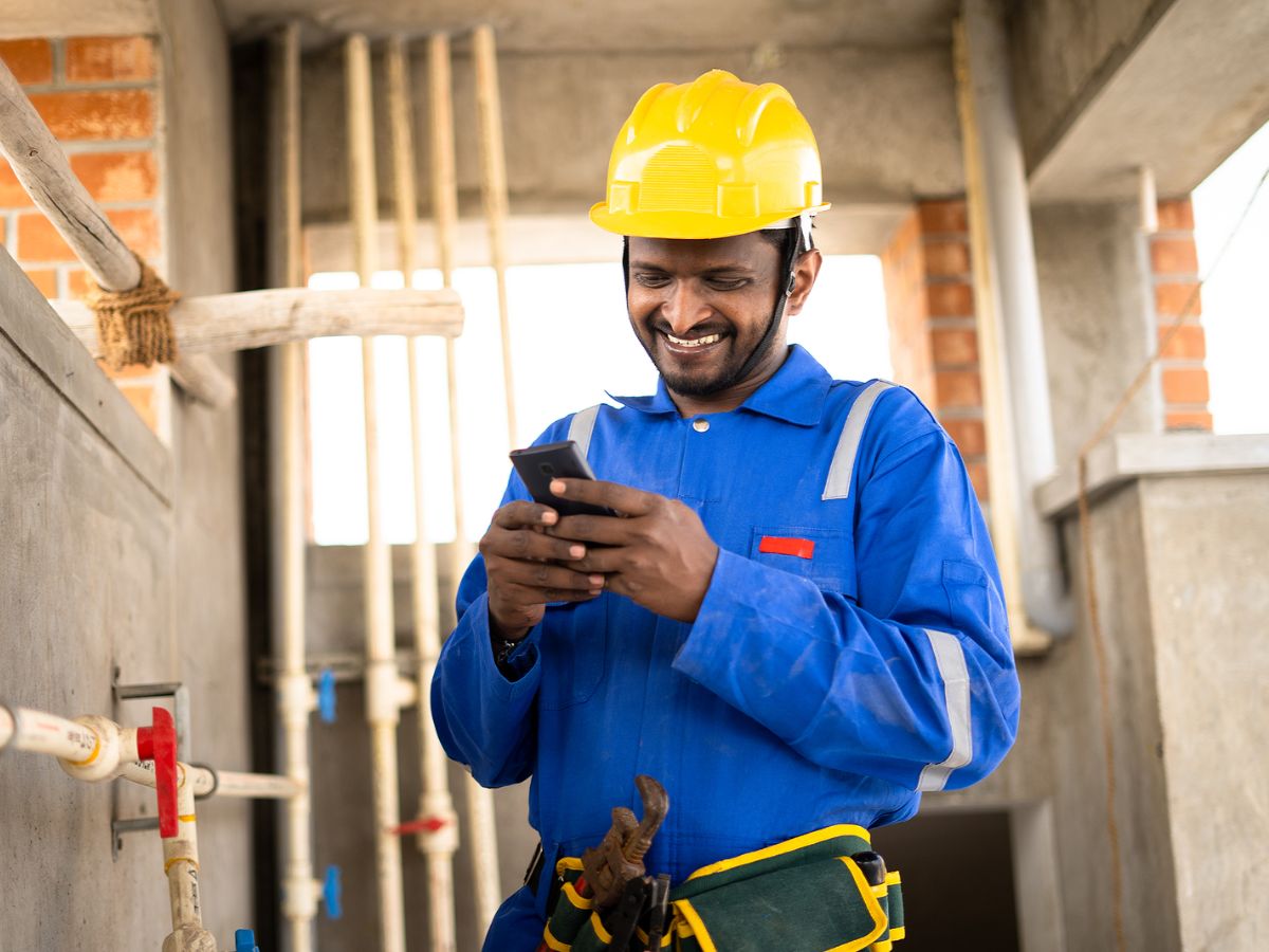 Electrician looking at phone on a work site
