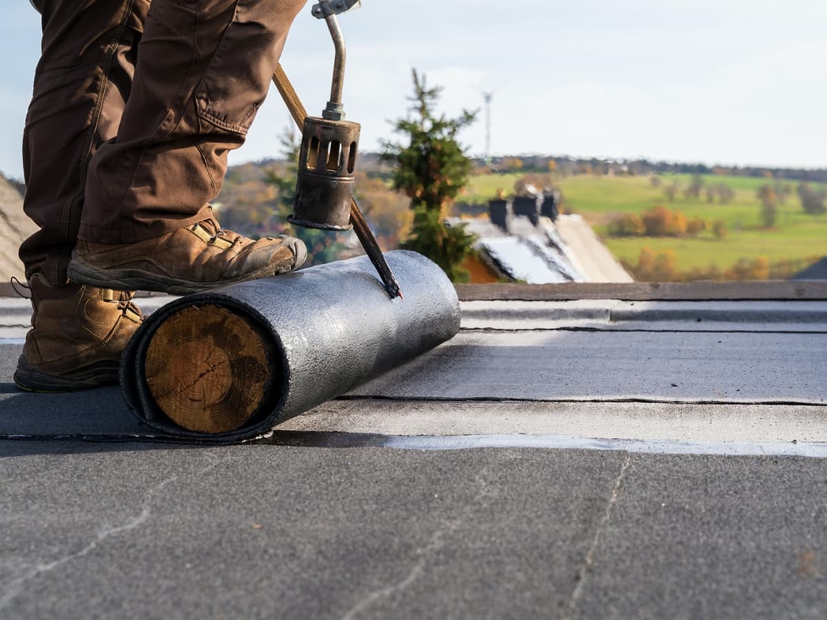Roofer using tool to install new roof.